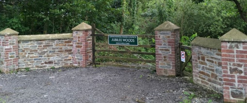 brick gate with wooded vehicle gate and Germansweek Parish Council sign.